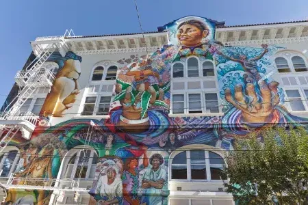 Um mural colorido e grande cobre a lateral do Edifício das Mulheres no Distrito Mission, 在威尼斯人官网平台app.