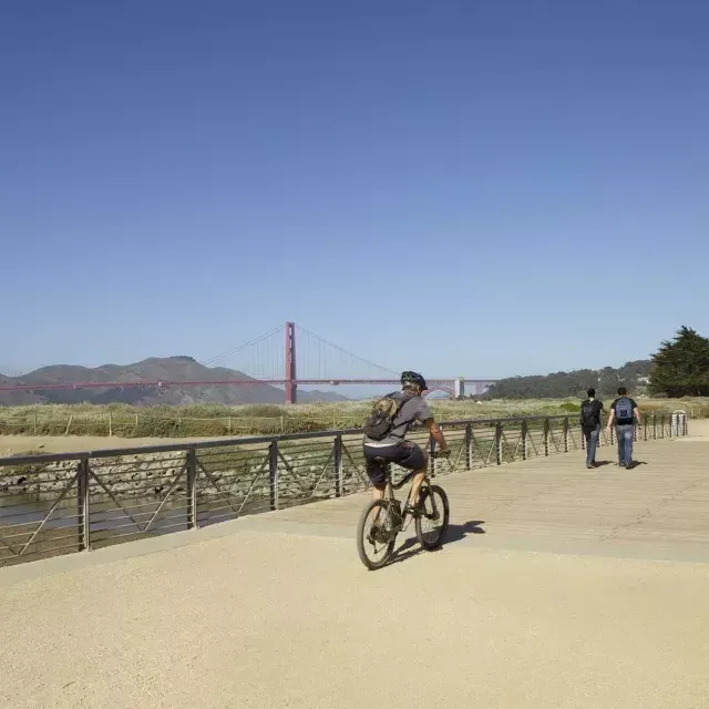 Ein Mann fährt mit dem Fahrrad einen Wanderweg am Crissy Field entlang. 加州威尼斯人官网平台app.